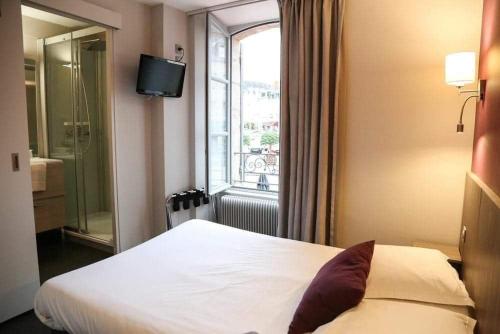 拉沙特尔HOTEL DU COMMERCE的酒店客房设有床和窗户。