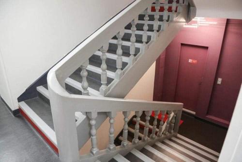 拉沙特尔HOTEL DU COMMERCE的一座红色门的建筑中的楼梯