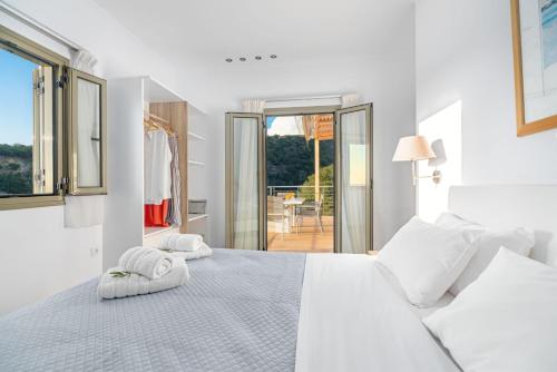 吉亚洛瓦Kosyforema Villas的白色卧室,配有带毛巾的床