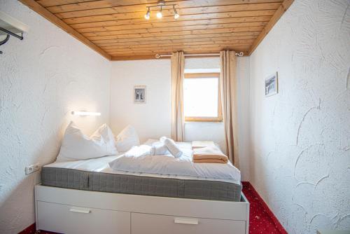 萨尔巴赫Schanzerhütte的一个小房间的一个床位,设有窗户