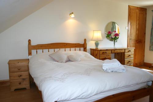普雷斯蒂克Garden Cottage的一间卧室配有一张床、梳妆台和镜子