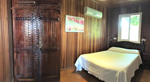 萨洛夫雷Casa Inmaculada Cabañas Mini Complejo Entero的一间卧室配有一张床和一个大型木制橱柜