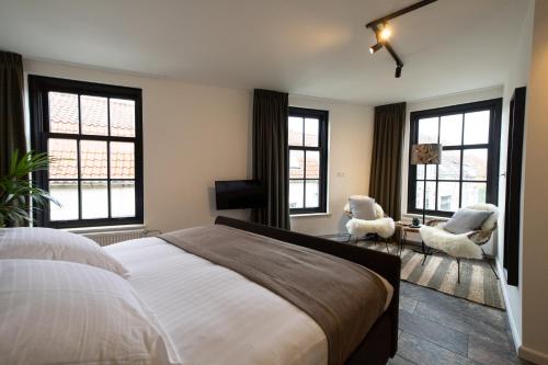 Oude-Tonge雷利餐馆及酒店的一间卧室配有一张床、两把椅子和窗户