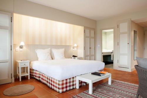 莫内斯捷维基斯酒店的一间带白色大床的卧室和一间客厅