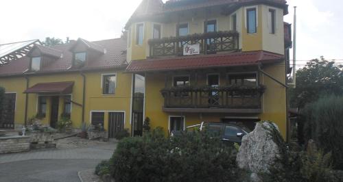 比克克森特凯赖斯特Dudás panzió的黄色房子的一侧设有阳台