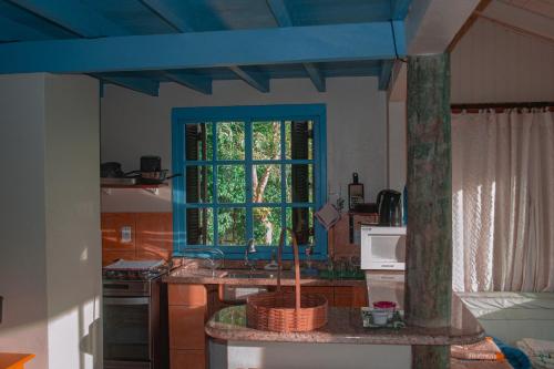 伊比拉奎拉Doce Cabana Pousada的厨房设有水槽和蓝色窗户。