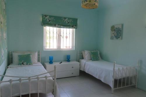 蓝海湾Villa De Rouba的一间卧室设有两张床和窗户。