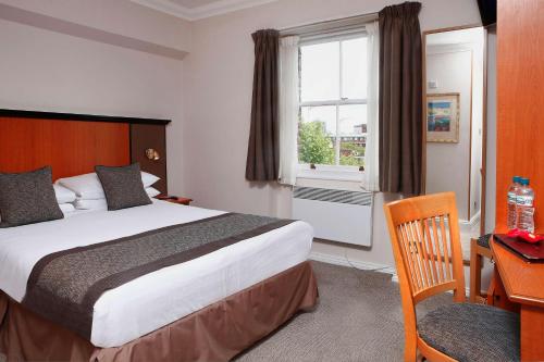 伦敦贝斯特韦斯特日冕酒店的配有一张床、一张书桌和一扇窗户的酒店客房