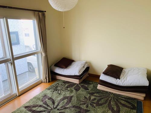 根室市Guesthouse TOMAYA的客房设有两张床和大窗户。