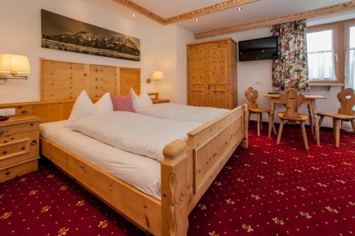 蒂罗尔州奥伯恩多夫基茨比厄尔阿尔卑斯山国王酒店的一间卧室配有一张大床和一张桌子