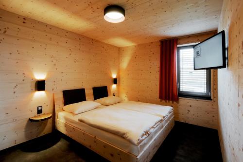 措伊伦罗达MANOAH- Häuser am See的一间卧室配有一张床和一台平面电视