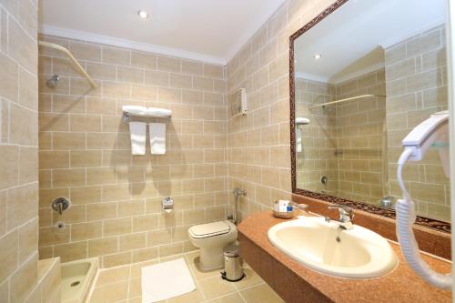 赫尔格达Sunny Days Mirette Family Resort的一间带水槽、卫生间和镜子的浴室
