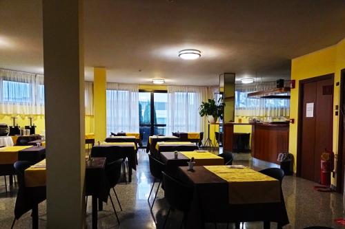 奥索纳Hotel Motel Europa的餐厅设有桌椅和黄色的墙壁