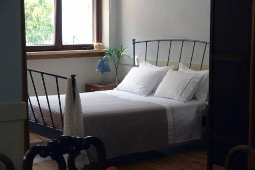 雅典Unique - Spacious Studio with rooftop / Thissio的一间卧室配有带白色床单和枕头的床。