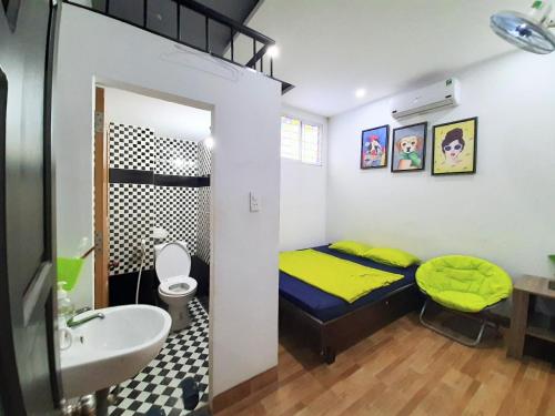 岘港Homestay Xì Trum的一间小卧室,配有黄色的床和水槽