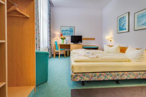 梅森迈森旧钢琴厂酒店的配有一张床和一张书桌的酒店客房