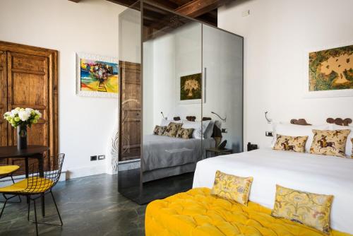 罗马Palazzo Delle Pietre - Luxury Apartments的卧室配有一张白色大床和一张黄色沙发。