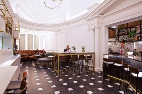 伦敦The Z Hotel Holborn的一间带桌椅和天花板的餐厅