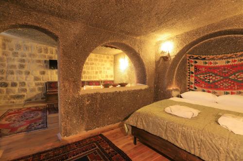 格雷梅Antique Terrace Cave Suites的石墙客房的卧室配有一张床
