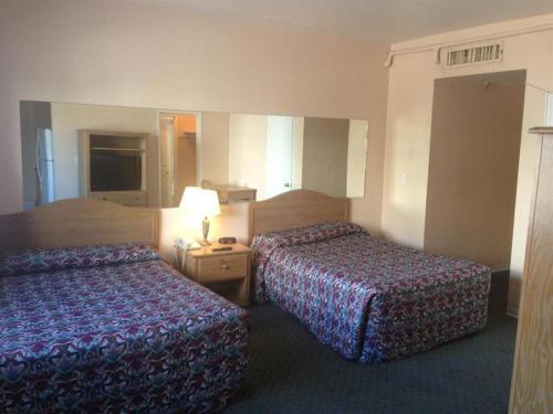 迈阿密海滩考林斯街道旅馆的酒店客房,设有两张床和一盏灯
