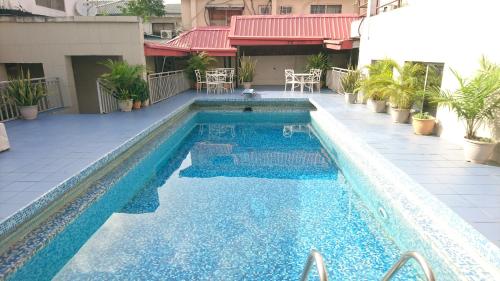 拉各斯The Ambassadors Hotel的大楼内的一个蓝色海水游泳池