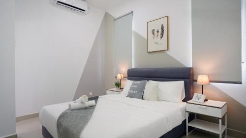 迪沙鲁Desaru Minimalism Muji Style by Joyfully 35M7的一间卧室配有一张白色的床和蓝色床头板