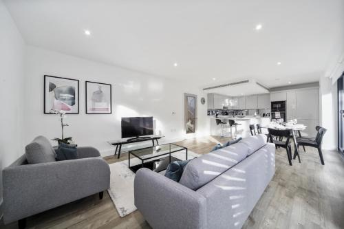 伦敦Executive Apartments in Bermondsey FREE WIFI & AIRCON by City Stay Aparts London的一间带两张沙发的客厅和一间用餐室