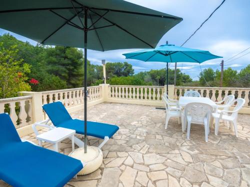 圣卡洛斯托尼马里别墅的一个带桌椅和遮阳伞的庭院