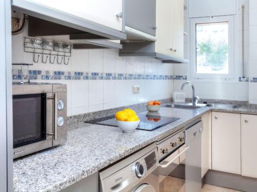 兰卡Apartment Cap Ras II by Interhome的白色的厨房,柜台上放着一碗水果