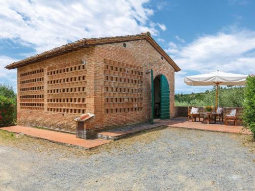 帕拉伊阿Holiday Home Fienile - PAA132 by Interhome的砖砌的建筑,配有桌子和雨伞