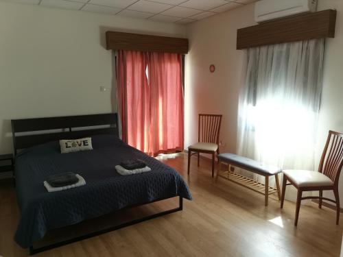 卡科佩特里亚Kakopetria Heights的一间卧室配有一张床、两把椅子和一个窗户