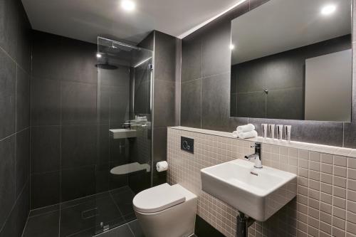 堪培拉Abode Belconnen的一间带卫生间、水槽和镜子的浴室