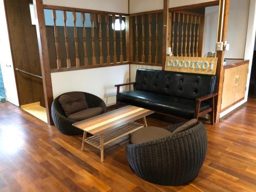 宫古岛宮古島ゲストハウス cocoikoi的客厅配有沙发和桌椅