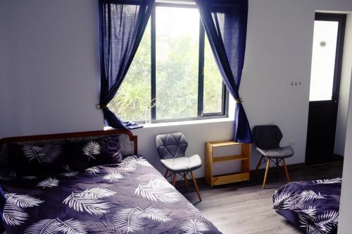 木州县Moc Chau Cottage homestay的一间卧室配有一张床、两把椅子和一个窗户