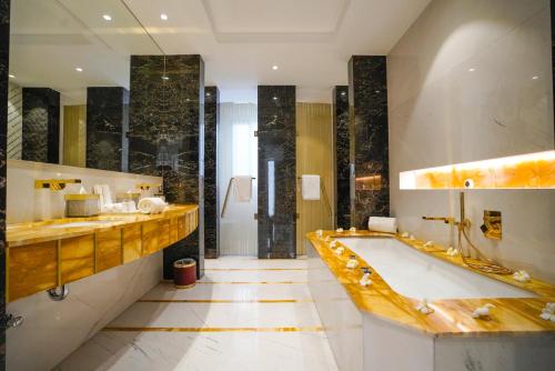 吉达Vivienda Hotel Villas, Jeddah的一间带大浴缸和水槽的浴室