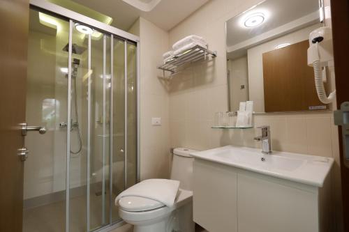 曼谷Justice Hotel的带淋浴、卫生间和盥洗盆的浴室