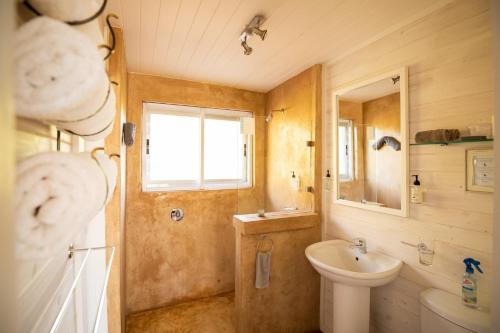 WolseleyBig Sky Cottages的一间带水槽、卫生间和镜子的浴室