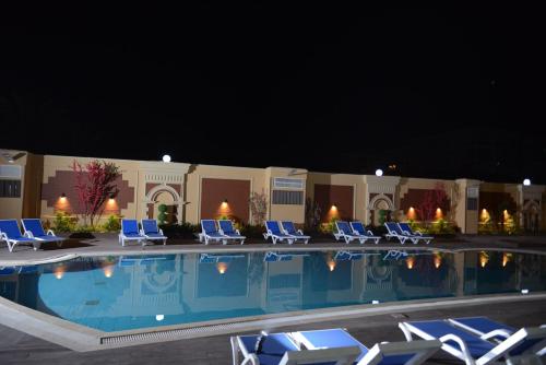 亚历山大阿尔蒙塔扎东方酒店的一个带躺椅的游泳池,晚上酒店