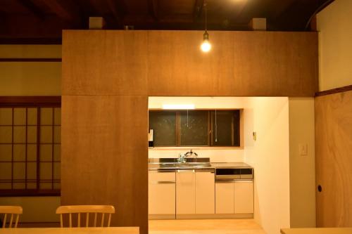 稻取湊庵錆御納戸-so-an sabionand-的厨房配有白色橱柜和水槽