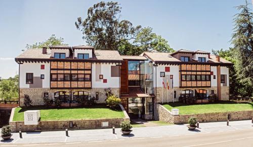 桑提亚纳德玛Hotel Cuevas - Adults Only的前面有绿色草坪的大房子
