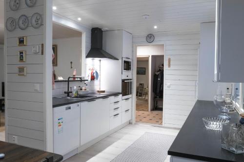 基蒂莱Talo-Villa- 3 mh+s - Kittilä - Levi upea keittiö的厨房配有白色橱柜和黑色台面