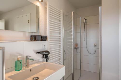 基姆湖畔布赖特布伦Design Ferienhaus 195qm的白色的浴室设有水槽和淋浴。