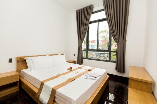 头顿Kim Minh Apartment & Hotel的一间卧室设有一张大床和一个窗户。