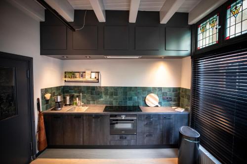 奥尔登扎尔OP10 Logeren的厨房配有棕色橱柜、水槽和炉灶。