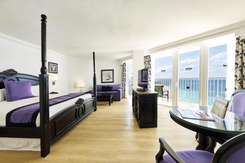 拿骚Riu Palace Paradise Island - Adults Only - All Inclusive的卧室配有一张床和一张桌子及椅子