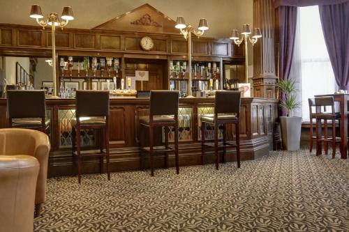 伯恩利Burnley North Oaks Hotel and Leisure Club的一间酒吧,里面配有椅子和柜台