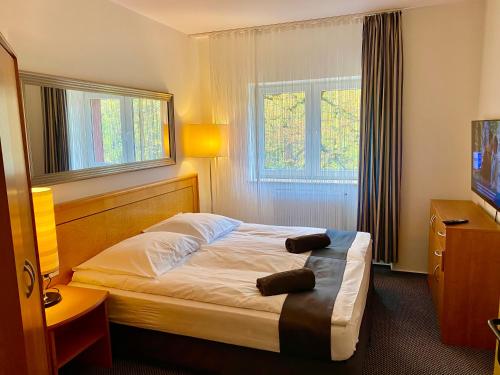 斯武普斯克Słupsk forest PREMIUM HOTEL APARTAMENT M6 - Kaszubska street 18 - Wifi Netflix Smart TV50 - two bedrooms two extra large double beds - up to 6 people full - pleasure quality stay的酒店客房,配有床和电视