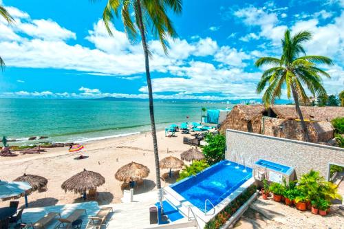 巴亚尔塔港Vallarta Shores Beach Hotel的享有海滩美景,设有遮阳伞和游泳池