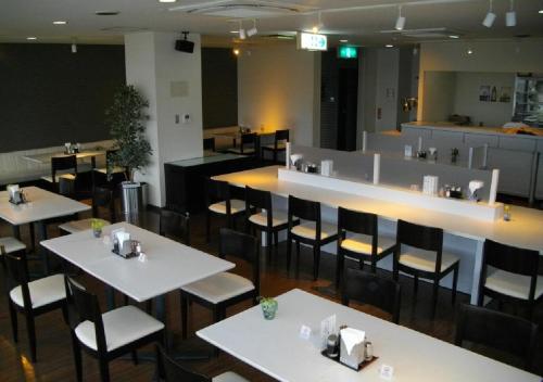 丰桥市Okadaya Bayside - Vacation STAY 00055v的一间设有白色桌椅的餐厅和一间酒吧