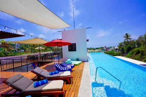 萨尤利塔Puerto Sayulita的一个带躺椅和红伞的游泳池